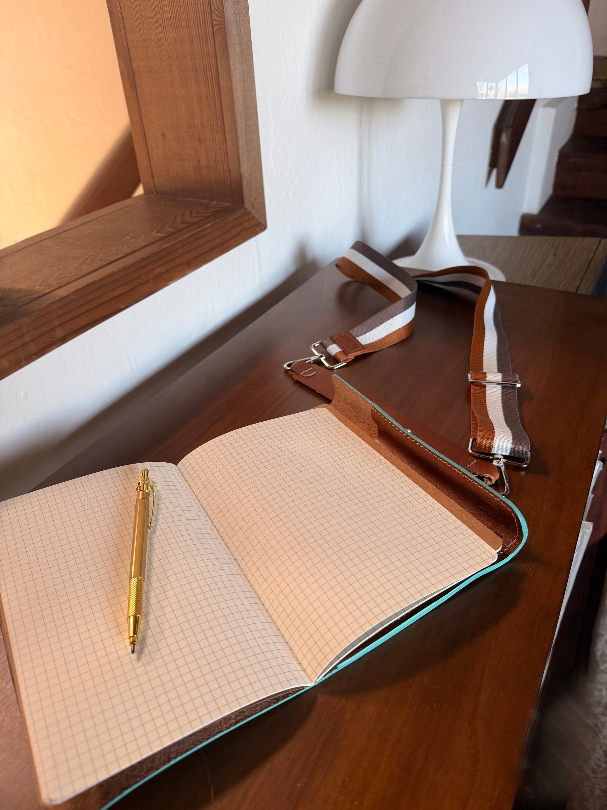 Open journal notebook with a pen on a wooden surface.